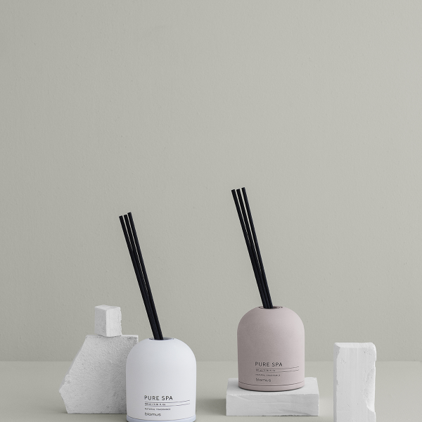 Elegante Sp diffuser auf einem minimalistischen Tisch mit strukturierten Elementen und neutralem Hintergrund.