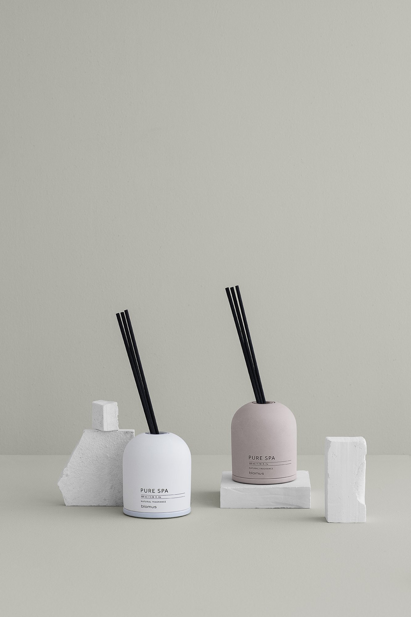 Elegante Sp diffuser auf einem minimalistischen Tisch mit strukturierten Elementen und neutralem Hintergrund.