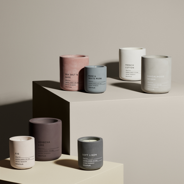 Stylish collection of scented candles in modern concrete containers on display.