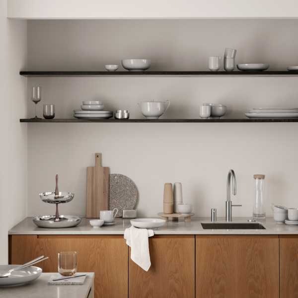 Minimalistische Küche mit Holzschränken, elegantem Geschirr und offenen Regalen.