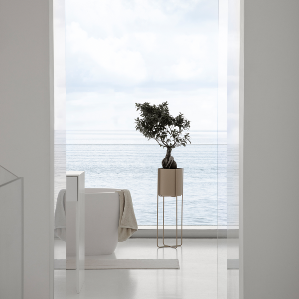 Modern bathroom with a view of the ocean featuring a potted plant and minimalist design.