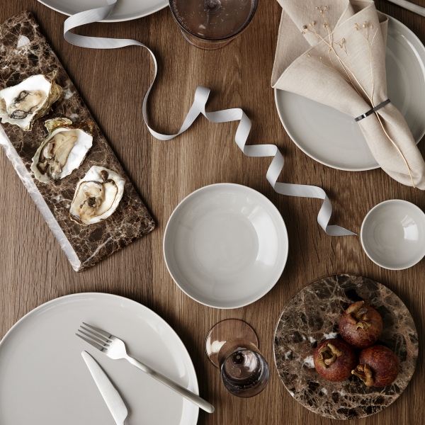 Elegant dining table setup with oysters, desserts, and refined tableware.