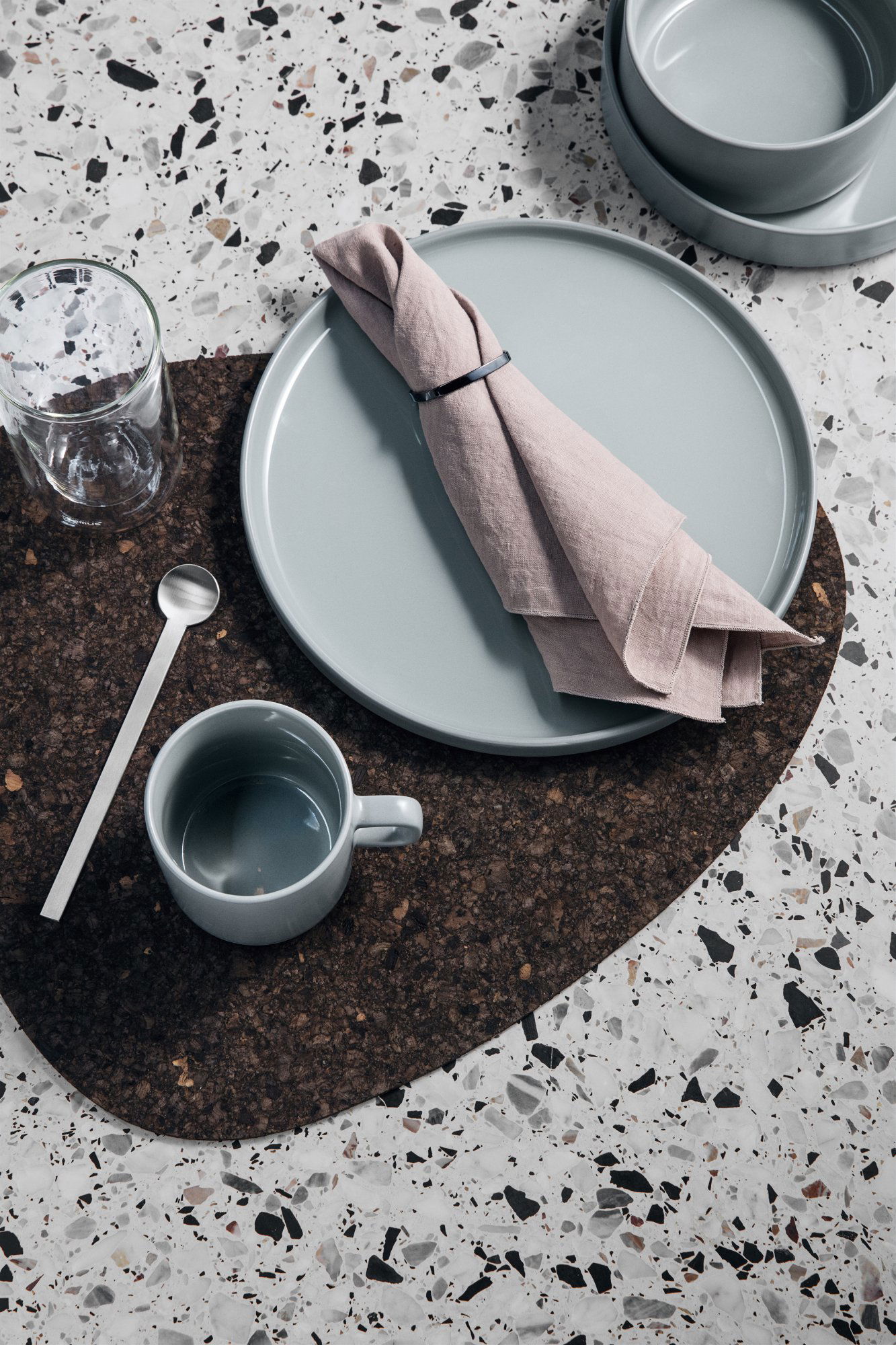 Beautifully arranged dining table setting with minimalist tableware and soft linen napkin.