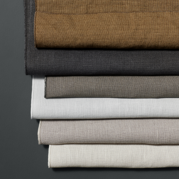 A stack of assorted linen fabric pieces in various neutral colors.