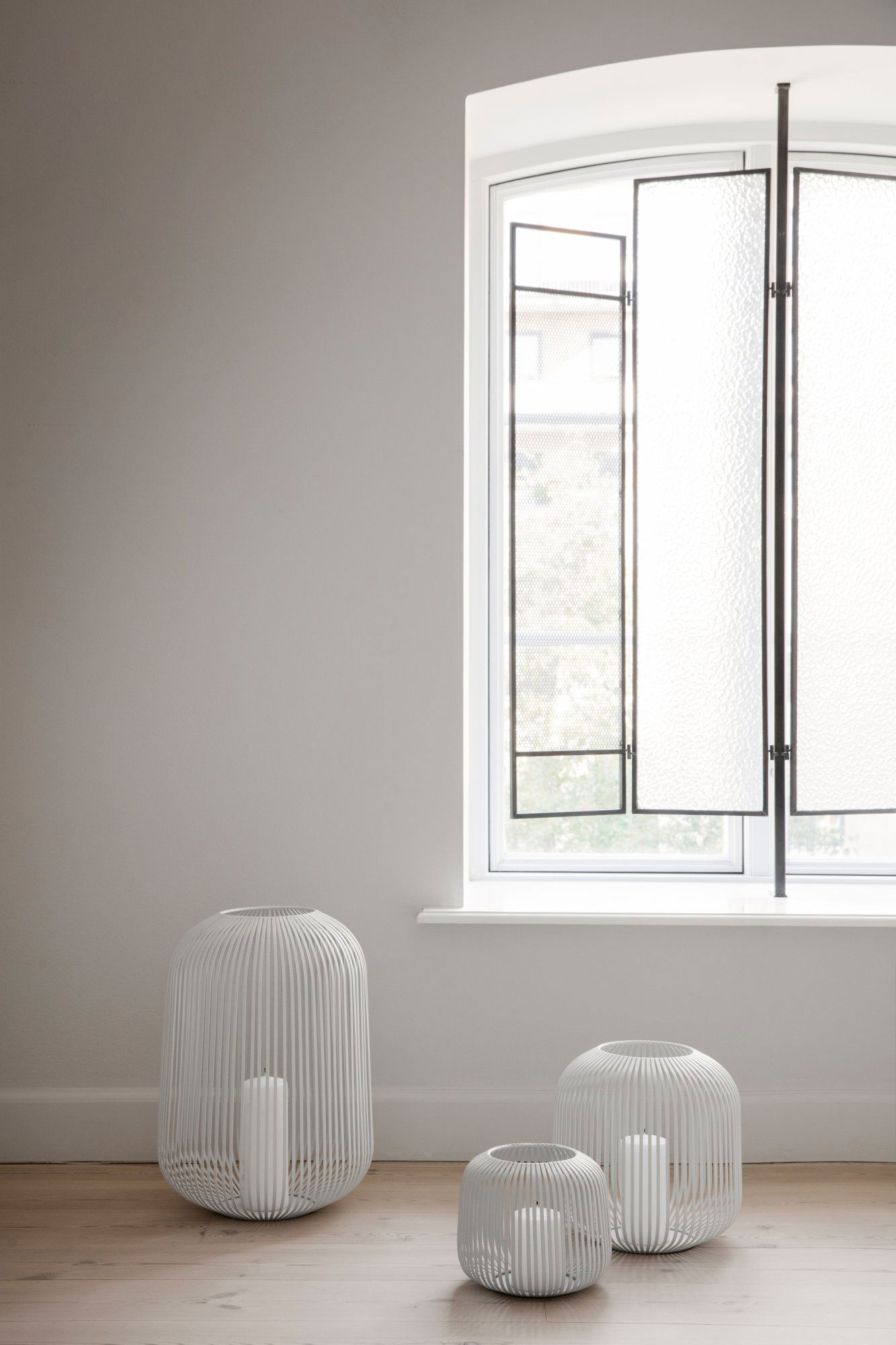 Moderne Innenausstattung mit minimalistischen weißen Vasen und einem großen Fenster mit einzigartigem Design.