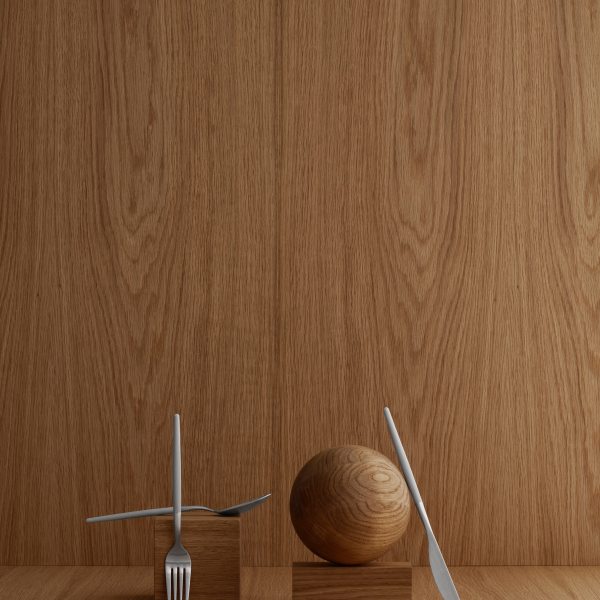 Minimalistische Kücheneinrichtung mit einer Gabel, einem Messer und einer Holzkugel vor einem Holzpaneel-Hintergrund.