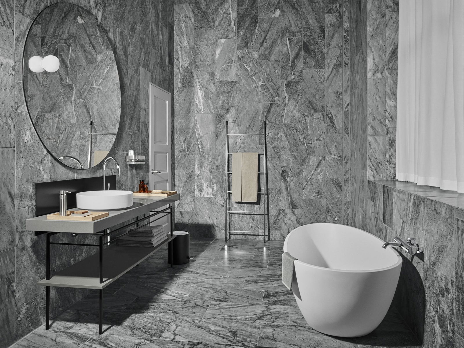 Luxurious gray marble bathroom featuring a modern freestanding bathtub and sleek fixtures.