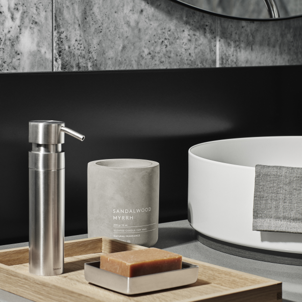 Elegant bathroom scene featuring sandalwood myrrh candle, soap, and stylish accessories.