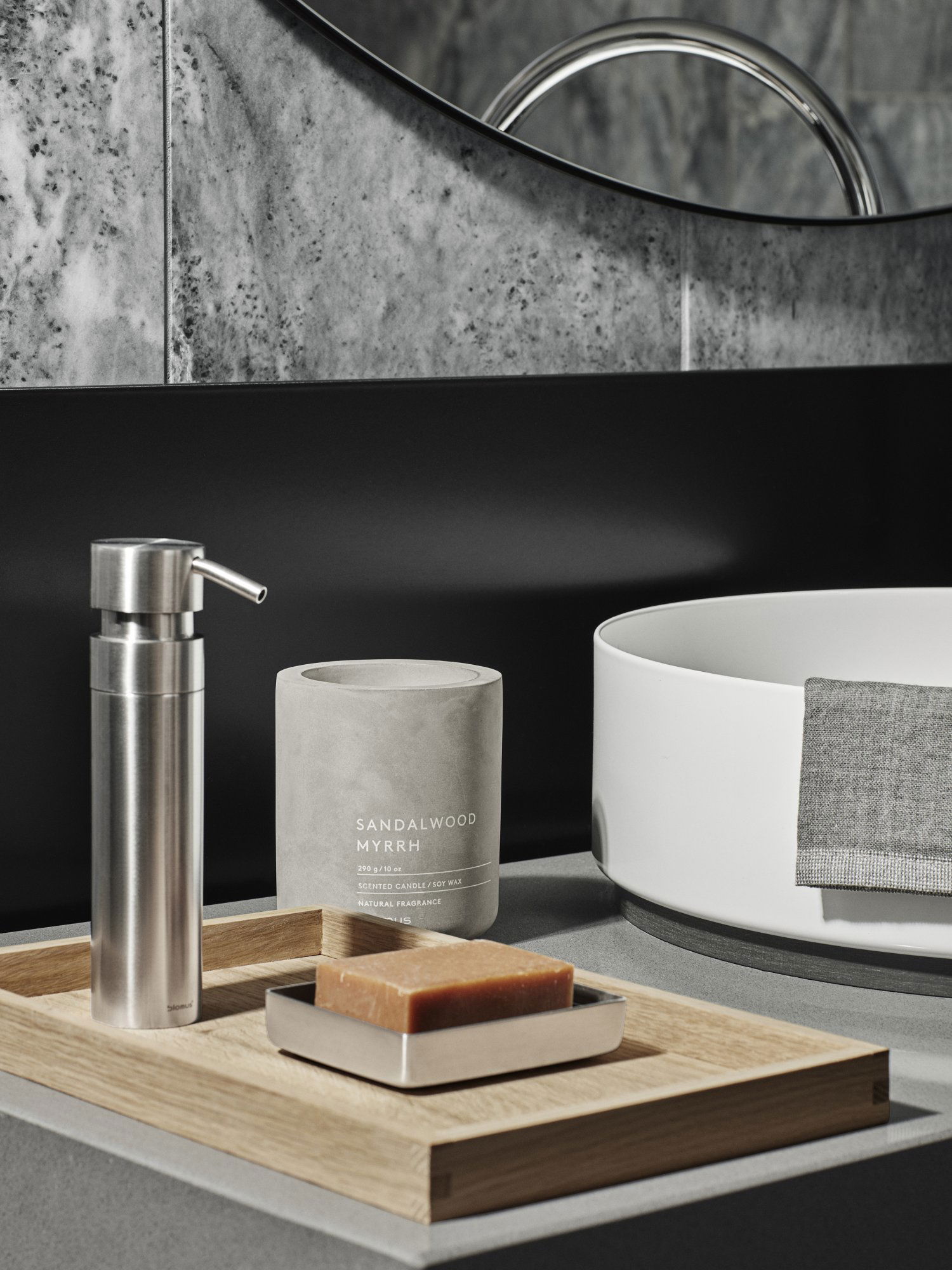 Elegant bathroom scene featuring sandalwood myrrh candle, soap, and stylish accessories.