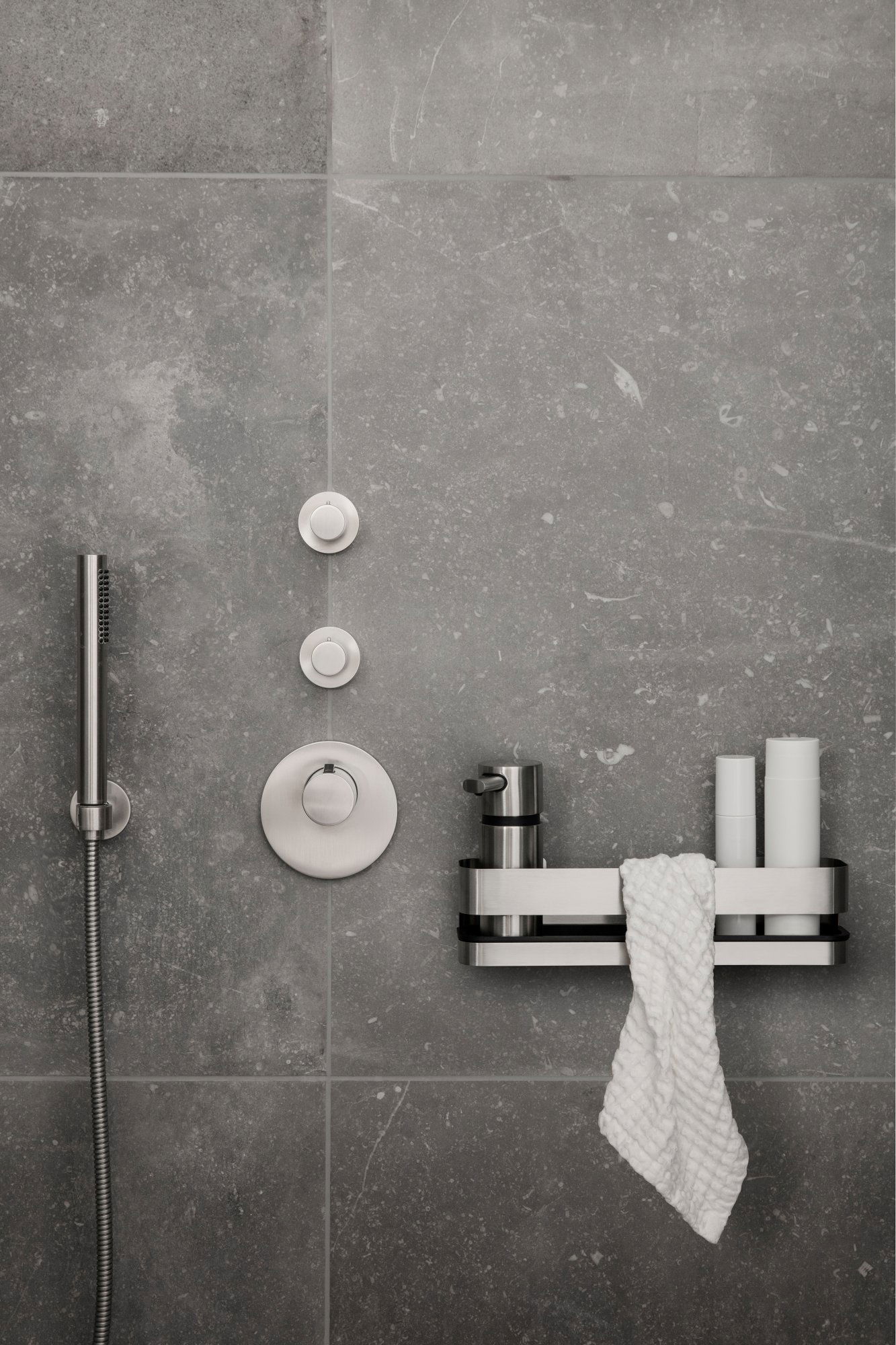 Modernes Badezimmerdesign mit eleganten Duschsteuerungen und stilvollen Aufbewahrungsaccessoires.