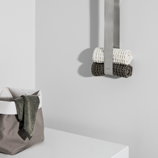 Modernes Badezimmer mit ordentlich gerollten Handtüchern und einem stilvollen Aufbewahrungskorb.