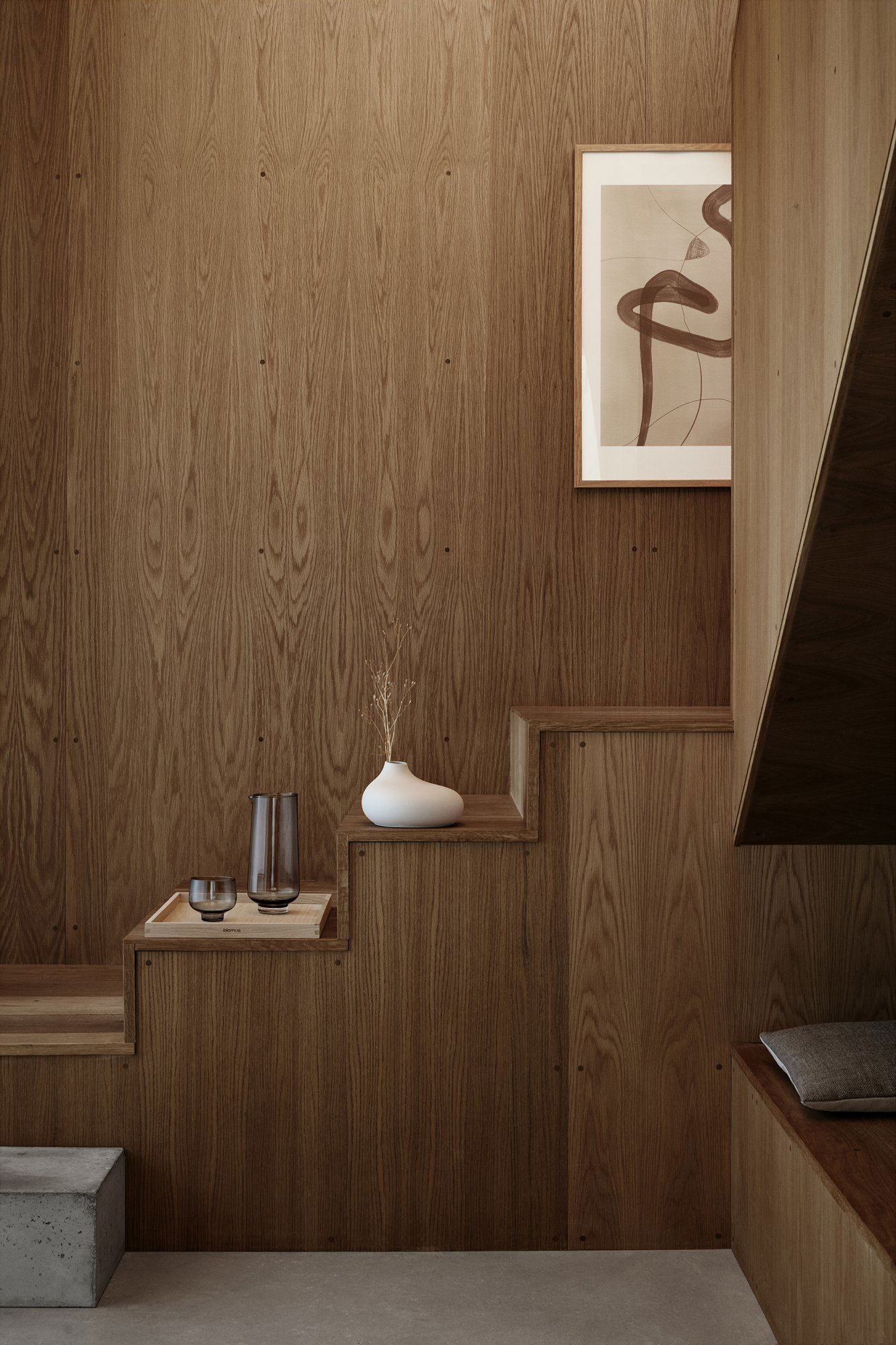 Elegante Holztreppe mit minimalistischem Dekor und abstrakter Wandkunst.