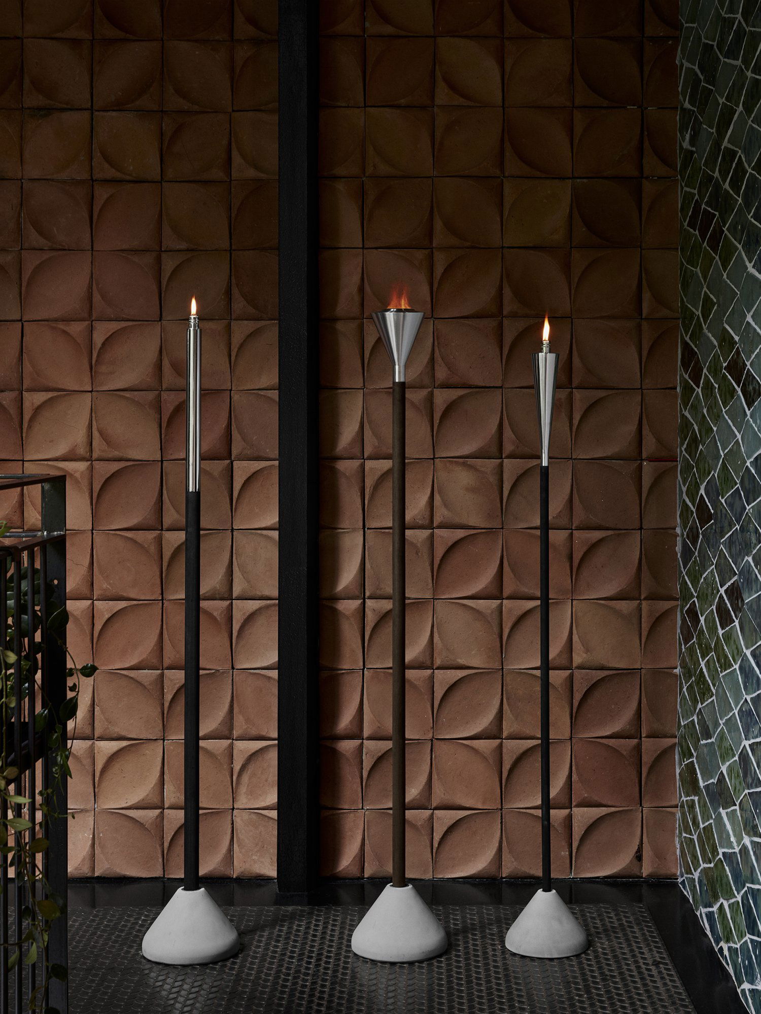 Stylische Wand mit strukturierten Fliesen und eleganten Wandleuchten im Fackelstil.