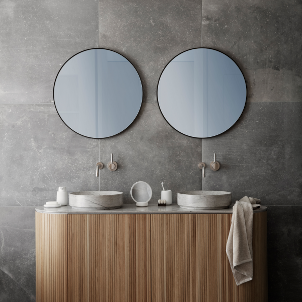 Moderne Badezimmergestaltung mit doppelten runden Spiegeln über einem Holzwaschtisch mit Waschbecken.