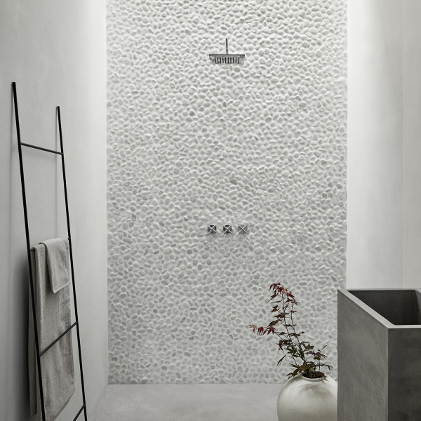 Moderne Dusche mit Kieselmauer, eleganten Armaturen und minimalistischer Dekoration in einem stilvollen Badezimmer.
