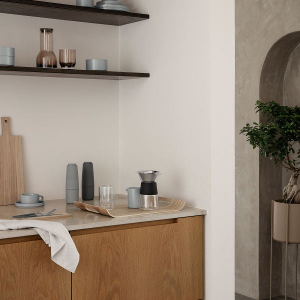 Moderner Küchenwinkel mit Holzmöbeln, stilvollem Geschirr und minimalistischer Dekoration.