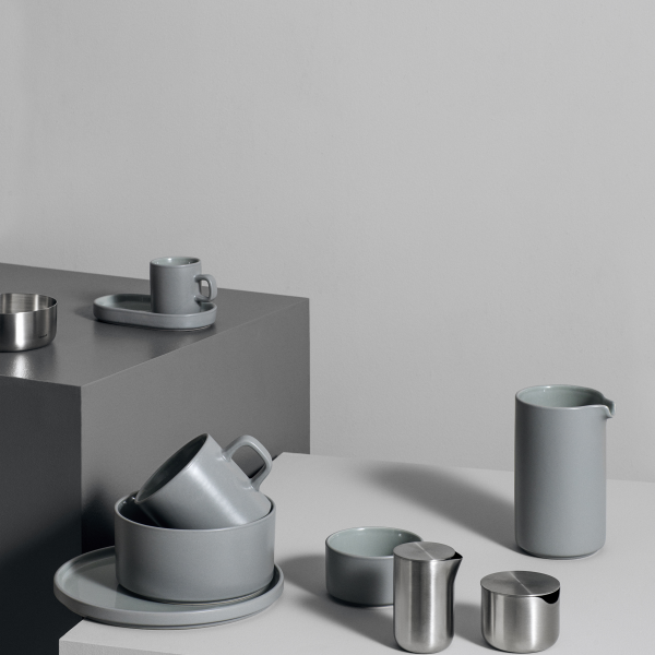 Elegantes graues Küchenzubehör auf minimalistischen Oberflächen, das modernes Design und Einfachheit zeigt.