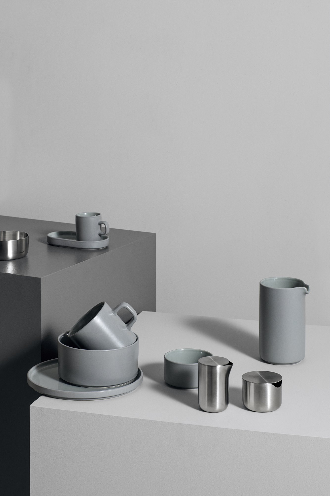 Elegantes graues Küchenzubehör auf minimalistischen Oberflächen, das modernes Design und Einfachheit zeigt.