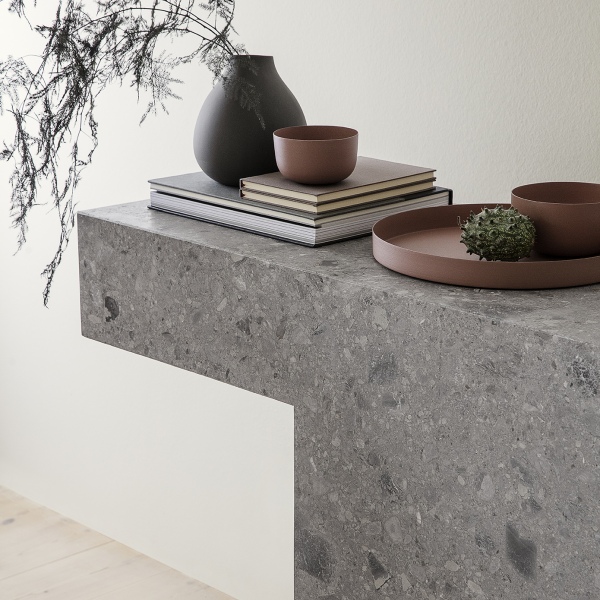 Modern gray stone table decor with minimalistic vases and bowls, enhancing a stylish interior.