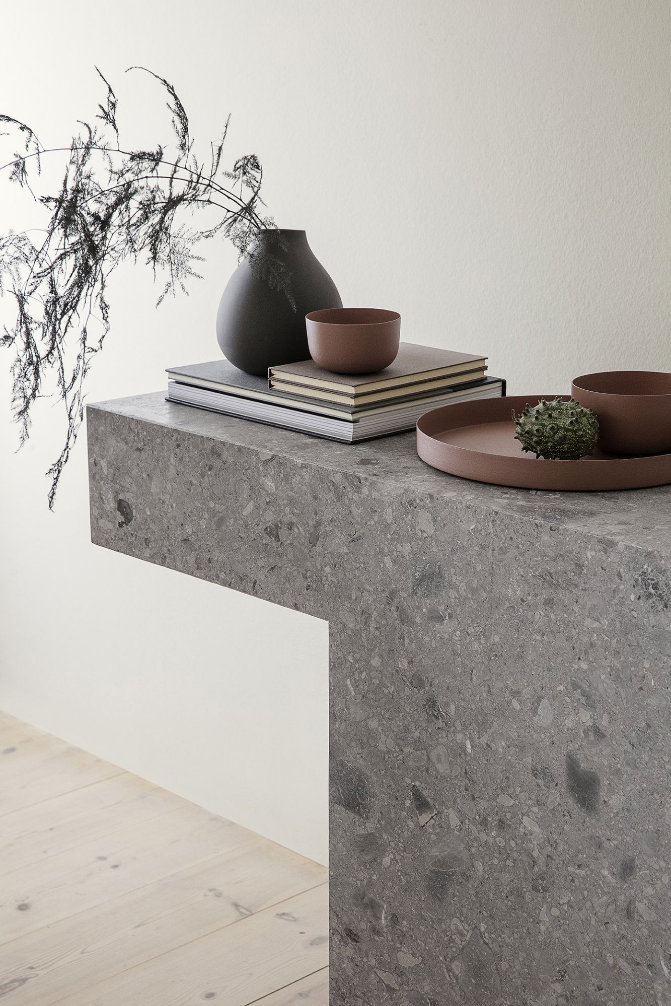 Modern gray stone table decor with minimalistic vases and bowls, enhancing a stylish interior.