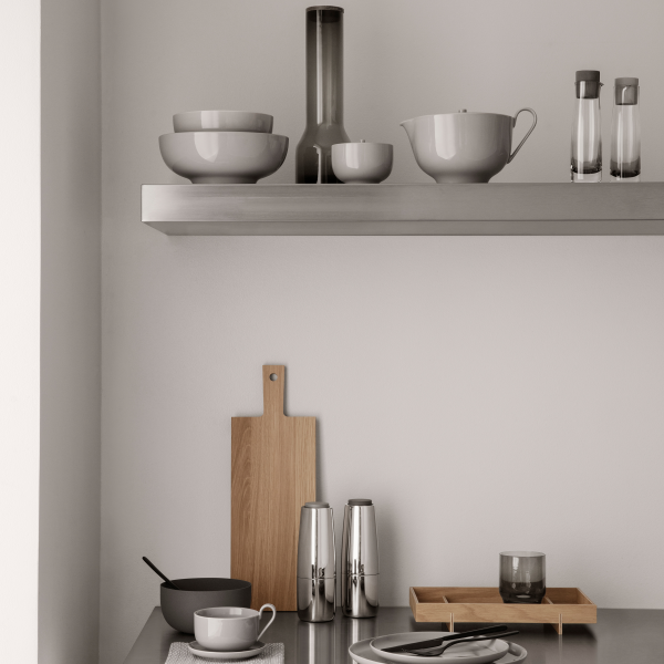 Modern kitchen shelf featuring minimalist tableware and stylish utensils in neutral tones.