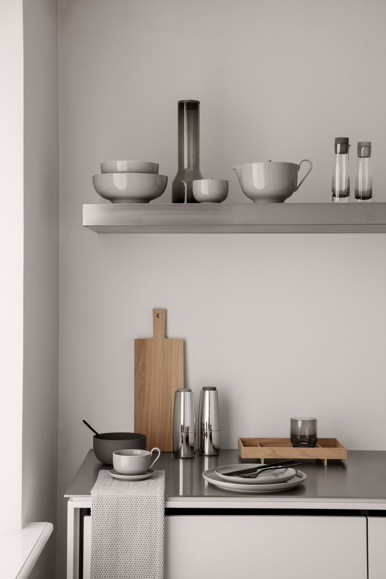 Modern kitchen shelf featuring minimalist tableware and stylish utensils in neutral tones.