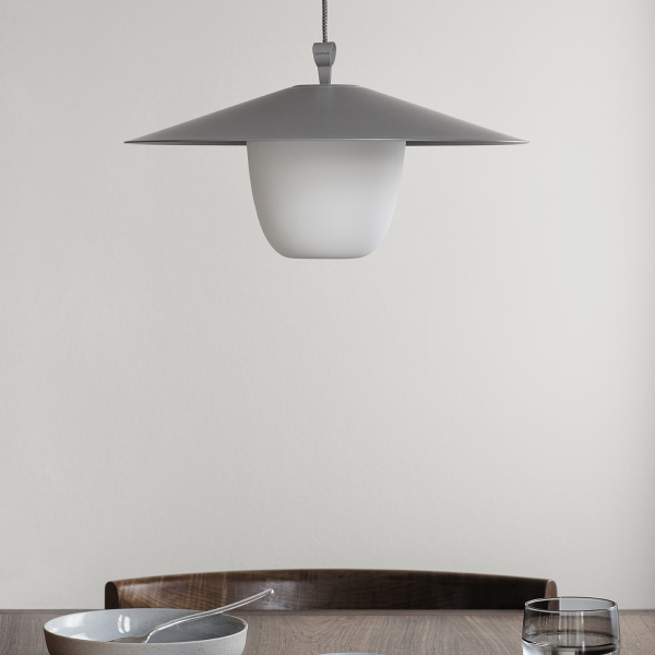 Moderne Pendelleuchte, die eine minimalistische Esszimmertischdekoration beleuchtet.
