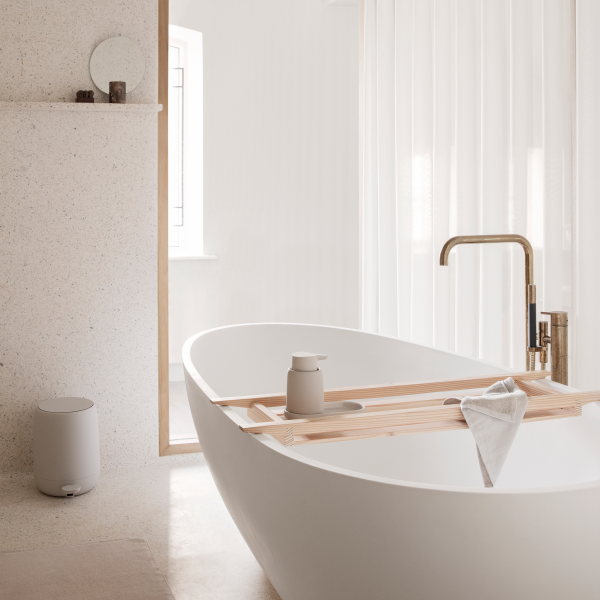 Modernes Badezimmer mit einer eleganten weißen Badewanne und minimalistischer Dekoration.