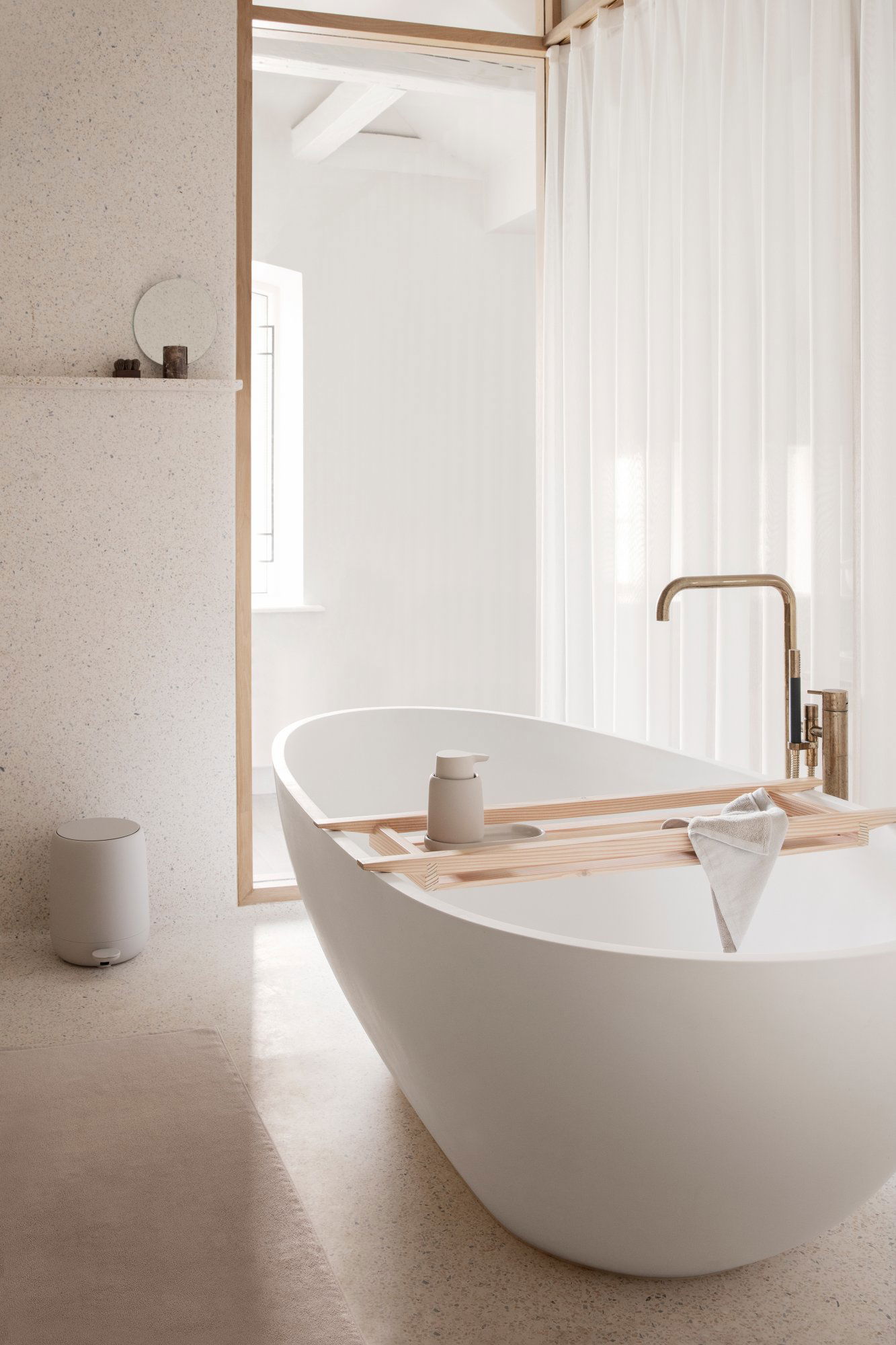 Modernes Badezimmer mit einer eleganten weißen Badewanne und minimalistischer Dekoration.