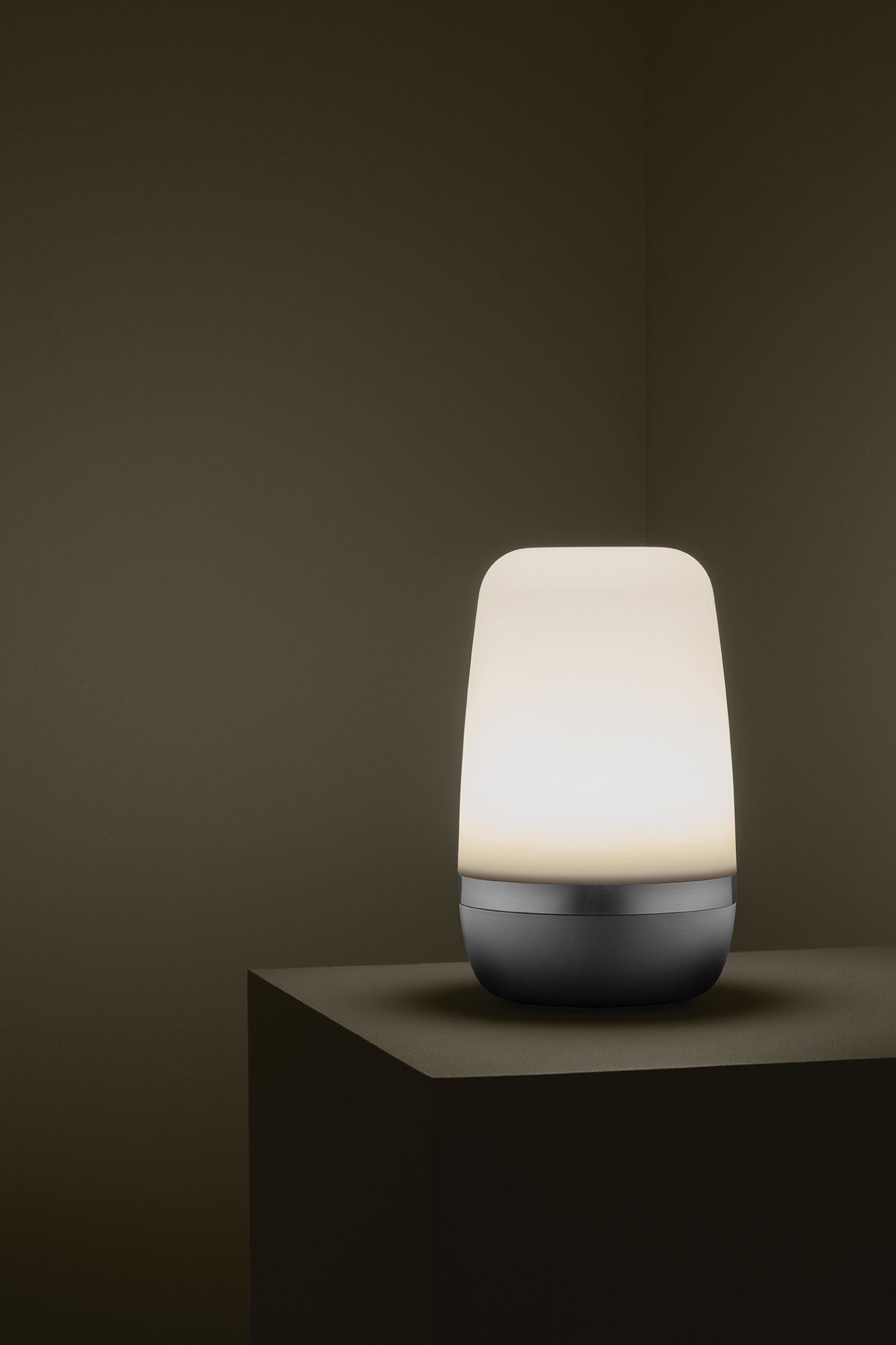Modern table lamp with a soft glow against a minimalistic dark background.