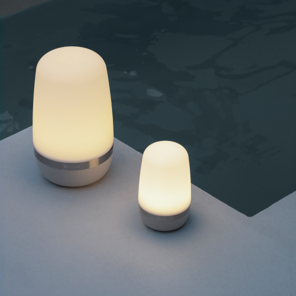 Soft glow of stylish outdoor lamps by a pool at night.