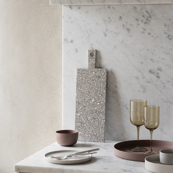 Elegante Küchenszene mit Terrazzo-Schneidebrett, Glaswaren und minimalistischen Geschirr.
