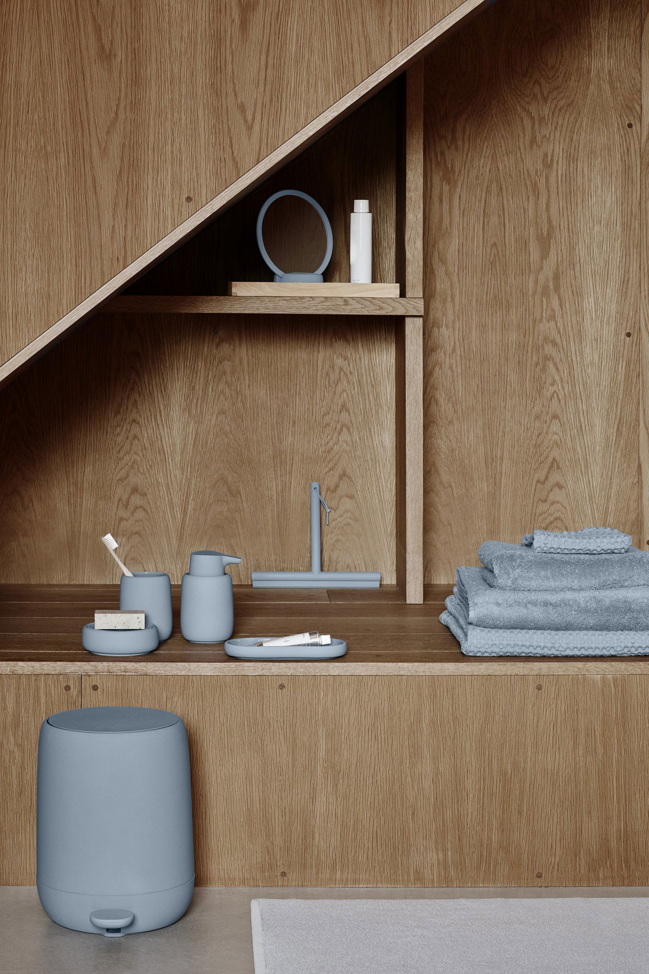 Elegante Badezimmerregalgestaltung mit sanften blauen Accessoires und Holzelementen.