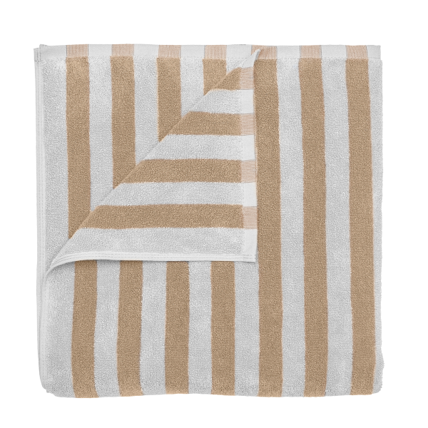 Striped beige and white towel folded neatly on a black background.
