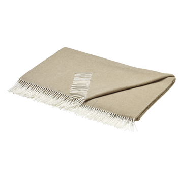 Gemütliche beige Decke mit weißen Fransen, perfekt für die Wohnkultur und Wärme.
