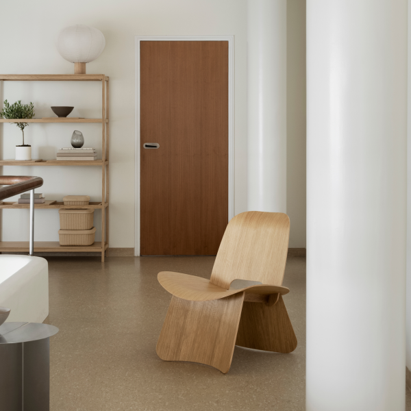 Moderne Holzstuhl in einem minimalistischen Innenraum mit natürlichem Licht und neutralen Tönen.