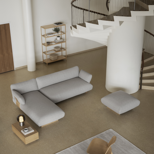 Modernes Wohnzimmer mit einem grauen Ecksofa, minimalistischer Dekoration und einer Wendeltreppe.