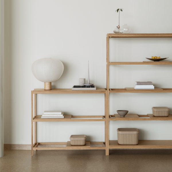 Moderne Holzregale mit minimalistischer Dekoration, einschließlich einer Lampe, Bücher und keramischen Behältern.