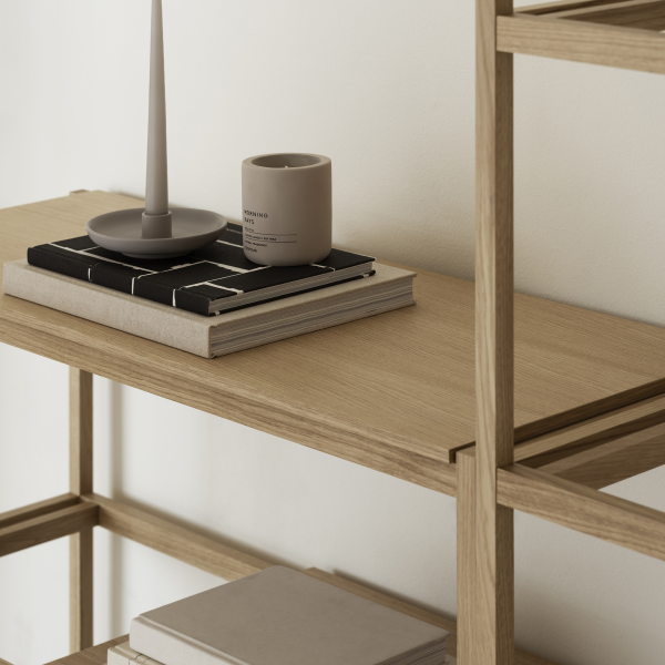 Stylish wooden shelf decor with books, a candle, and a minimalist vase.