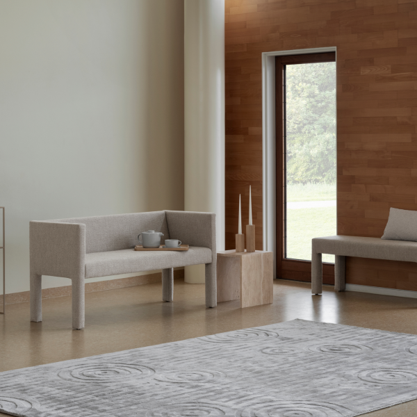 Modernes Wohnzimmer mit minimalistischer grauer Möbeln, holzverkleideten Akzenten und einem weichen Teppich.