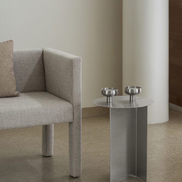 Modern living room with a gray sofa and metallic side table featuring two bowls.