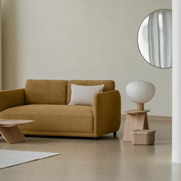 Stylisches Wohnzimmer mit einem senfgelben Sofa, modernem Dekor und einem eleganten runden Spiegel.