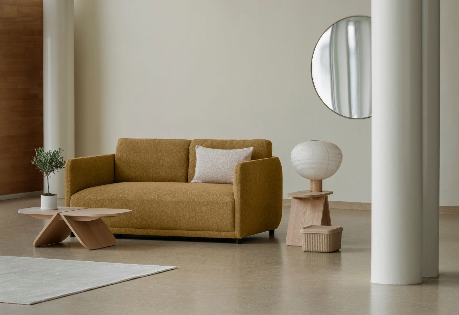 Stylisches Wohnzimmer mit einem senfgelben Sofa, modernem Dekor und einem eleganten runden Spiegel.