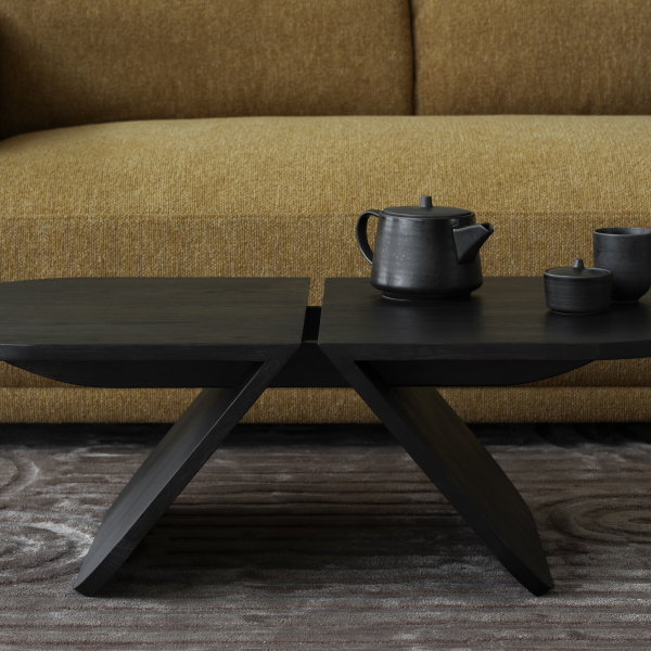 Stylish black coffee table with teapot and cups, set against a cozy yellow sofa.