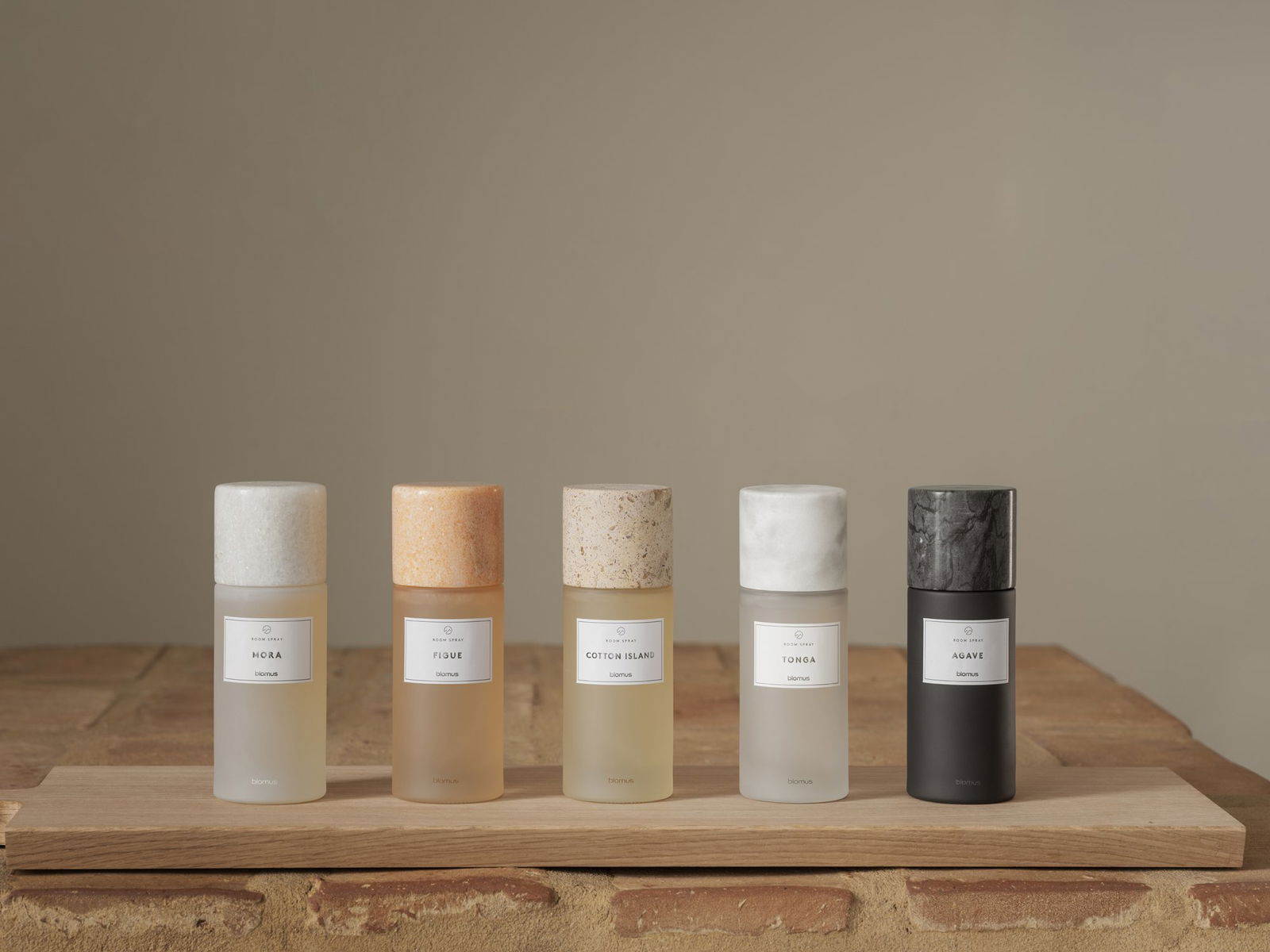 Elegante Präsentation von fünf Duftsprühflaschen im minimalistischen Design auf einer hölzernen Oberfläche.