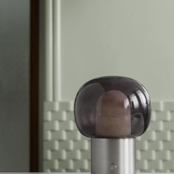 Moderne Glaslampe mit einem schlanken Design vor einem strukturierten Wandhintergrund.