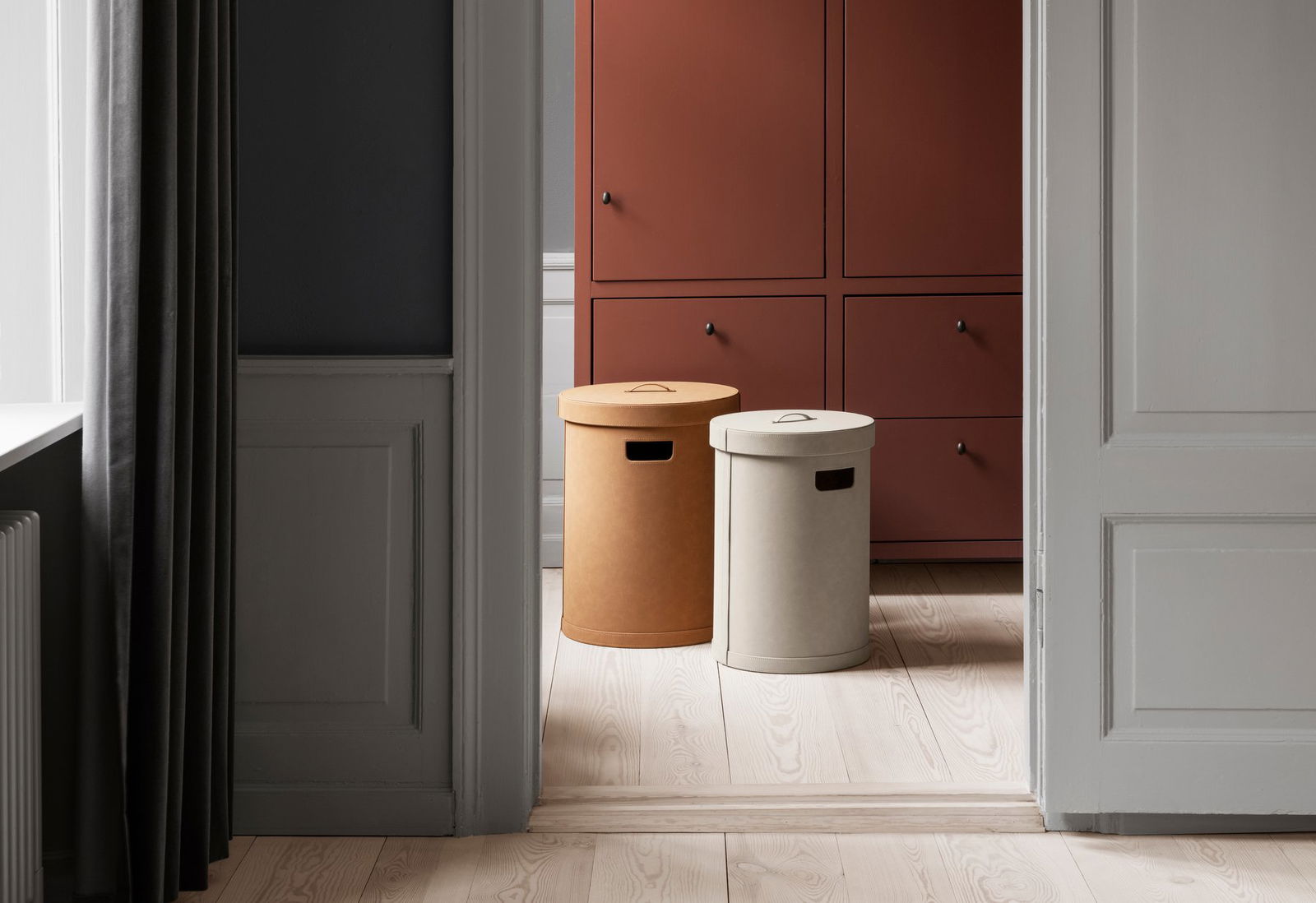 Stilvolle runde Aufbewahrungsboxen in Beige und Creme neben einem modernen Schrank in einem modernen Raum.