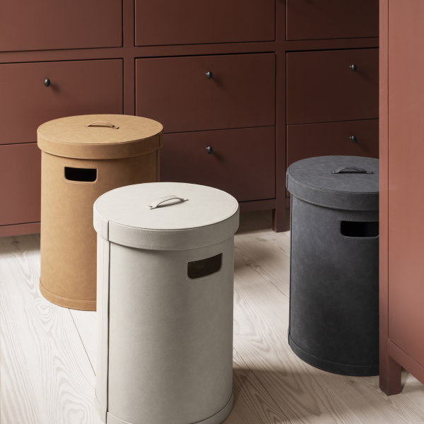 Schicke runde Aufbewahrungsbehälter in Beige, Grau und Braun auf einem Holzboden und in einem Schrank.