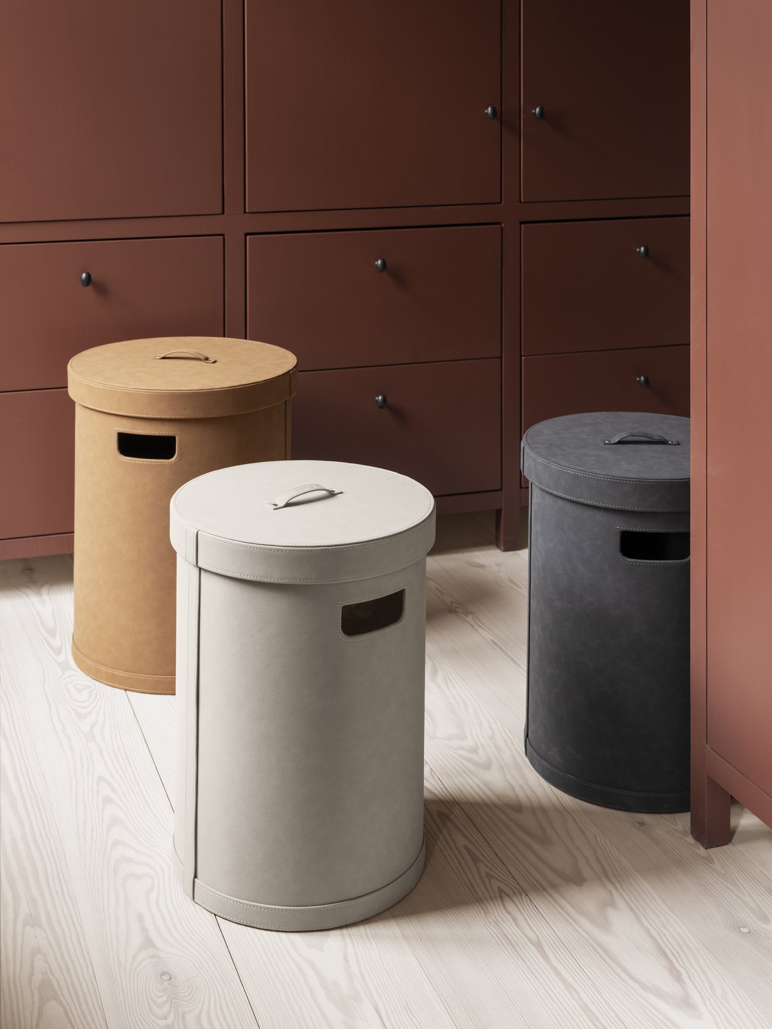 Schicke runde Aufbewahrungsbehälter in Beige, Grau und Braun auf einem Holzboden und in einem Schrank.