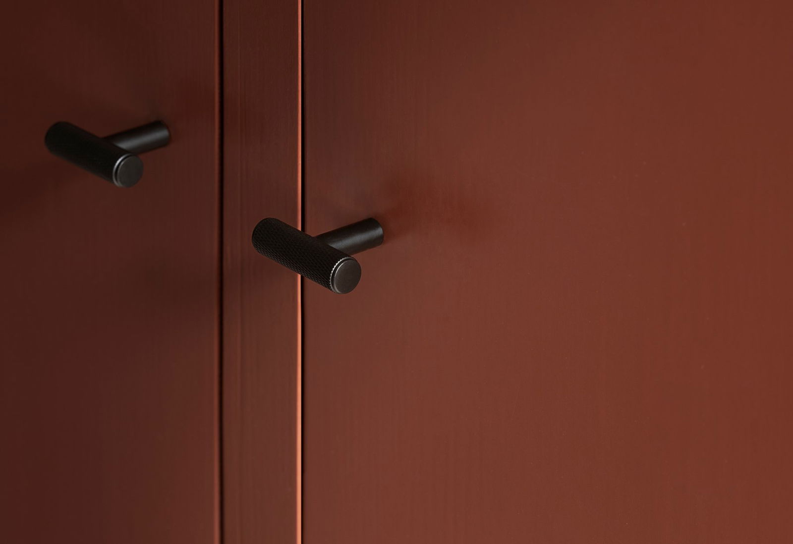 Moderner brauner Küchenschrank mit sleekem schwarzen Griff.